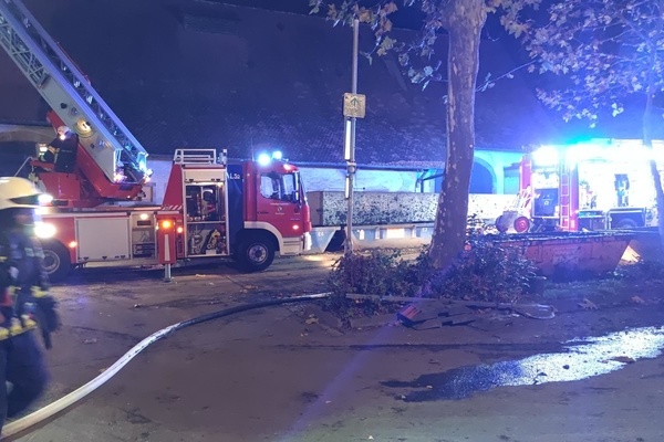 Zwei Lschfahrzeuge und eine Einsatzkraft vor einem Gebude