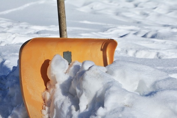 Weißer Schnee und eine orangefarbene Schneeschaufel