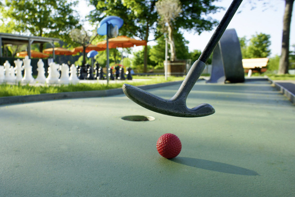 Minigolfschläger mit Minigolfball auf einer Minigolfbahn